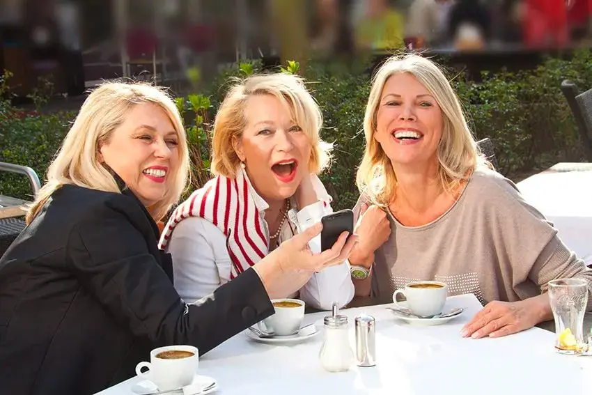 3 friends enjoy a laugh and coffee together