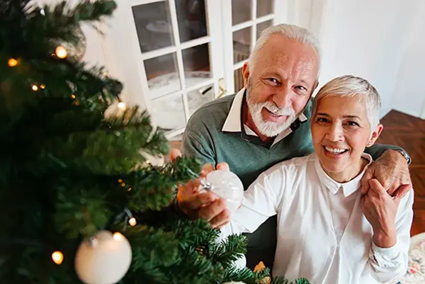 senior couple trimming their Christmas tree