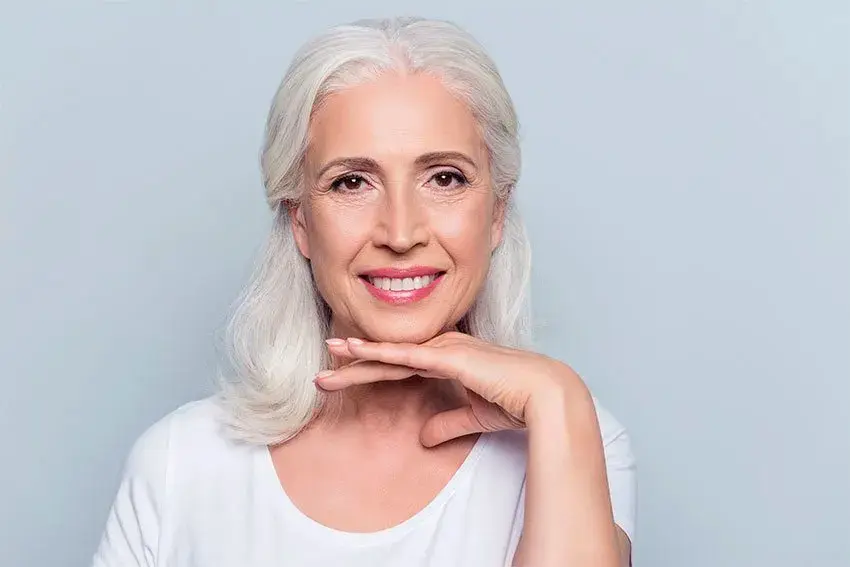 Give-Yourself-the-Gift-of-New-Dentures-This-Holiday-Season Beautiful mature woman outlying her smile