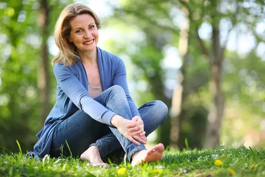 senior woman relaxing on the grass in a park