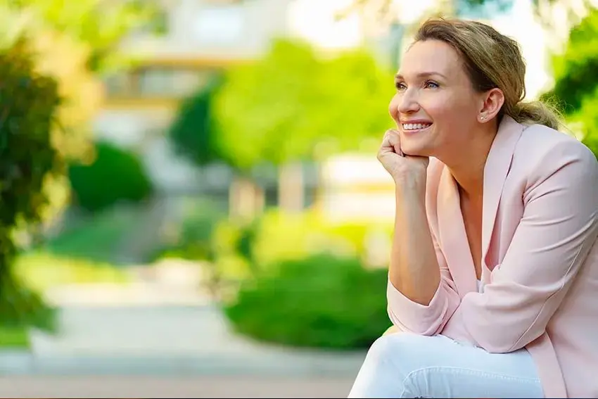 mature woman sitting on her front patio, look at the view.