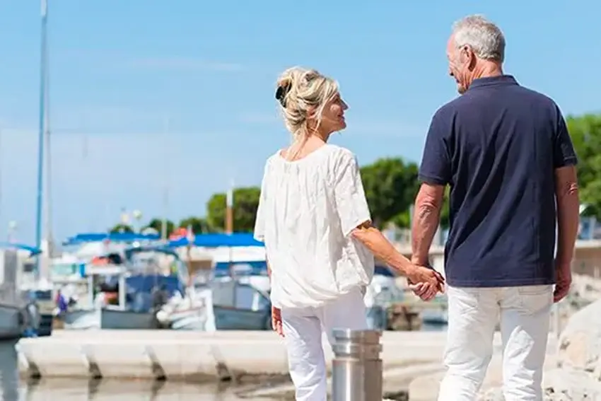 Implant Dentures Are Better for Travel-min Retired couple enjoying vacation near the lake