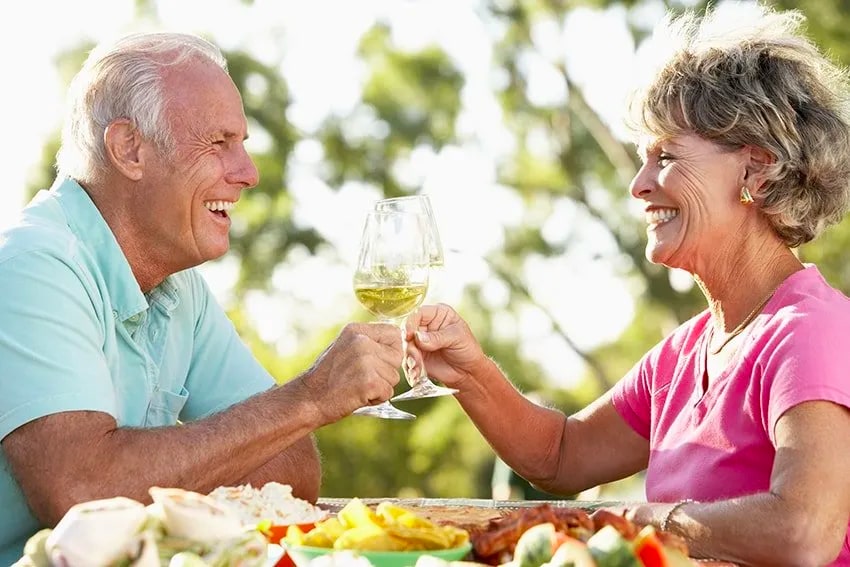 Senior couple celebrating with a glass of wine