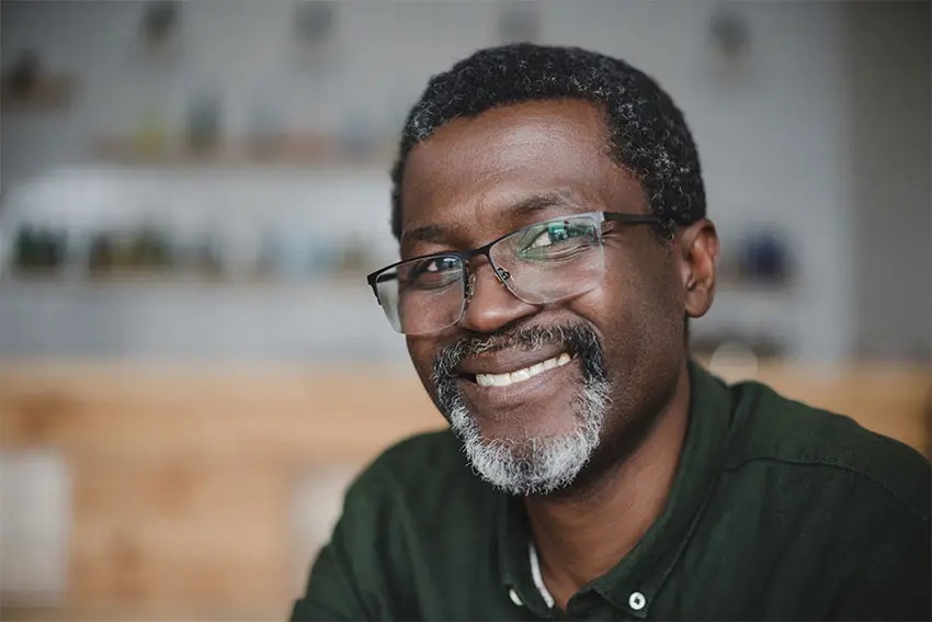 mature man with large eyeglasses shows off his big, wide smile