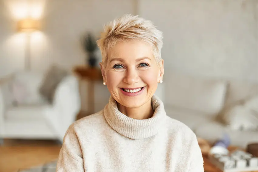 mature woman with short hair shows off her younger looking smile